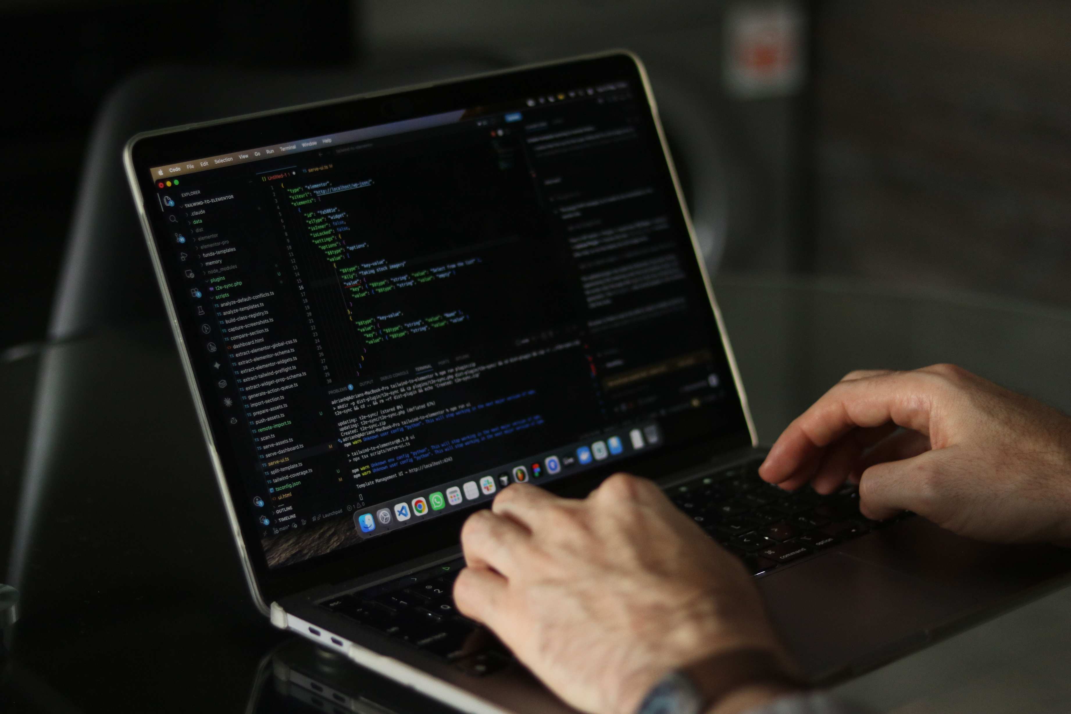 Hands on a laptop keyboard during migration scripting work